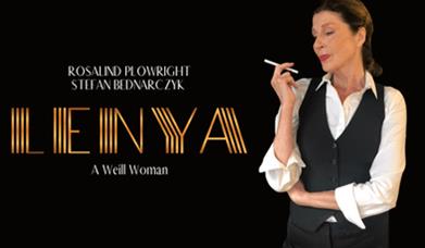 Woman in black waistcoat with white shirt, holding a cigarette near her mouth.