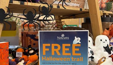 A spooky Halloween retail display with a sign explaining a free activity trail for children