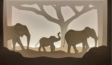 paper cut card with family of elephants